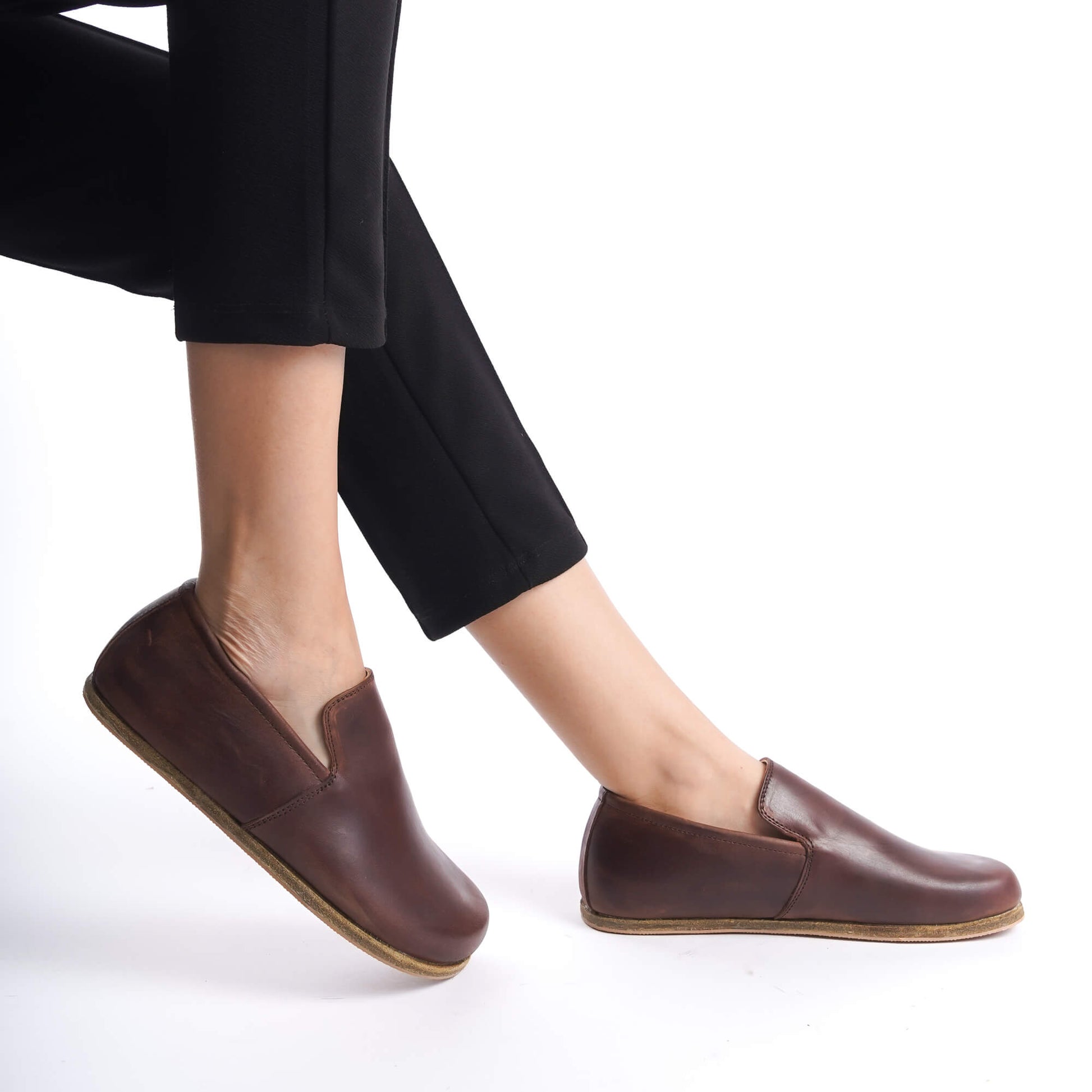 Model wearing black pants and Aeolia Brown Loafers, demonstrating the shoe's sleek design and comfortable fit in motion.