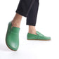 Close-up of Aeolia green leather barefoot women loafers, paired with black pants.