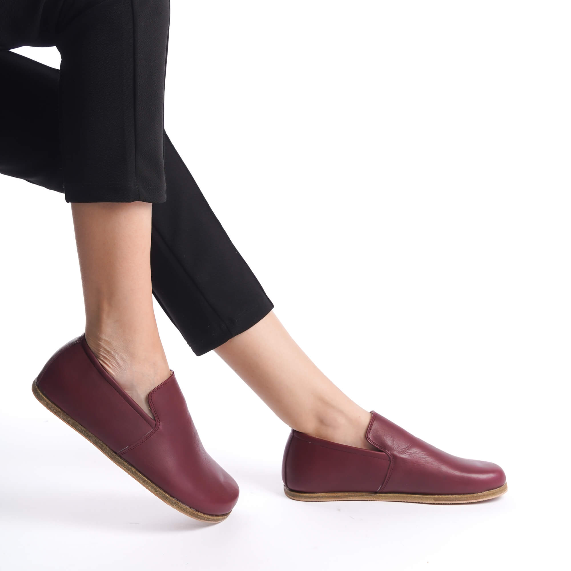 Loafers in Burgundy, shown with black pants, featuring a minimalist and comfortable barefoot design.