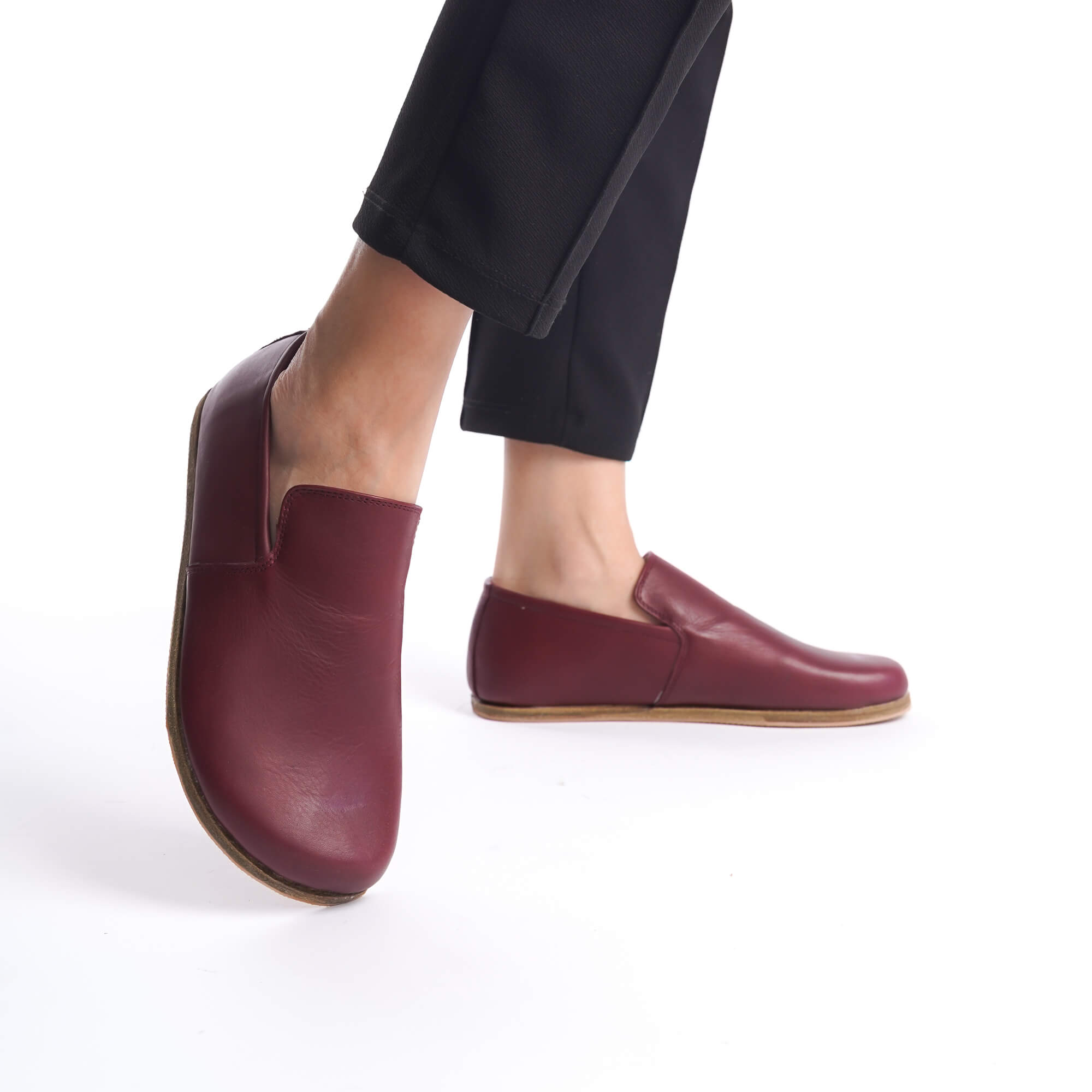 Close-up of Aeolia Leather Barefoot Women Loafers in Burgundy, paired with black pants.