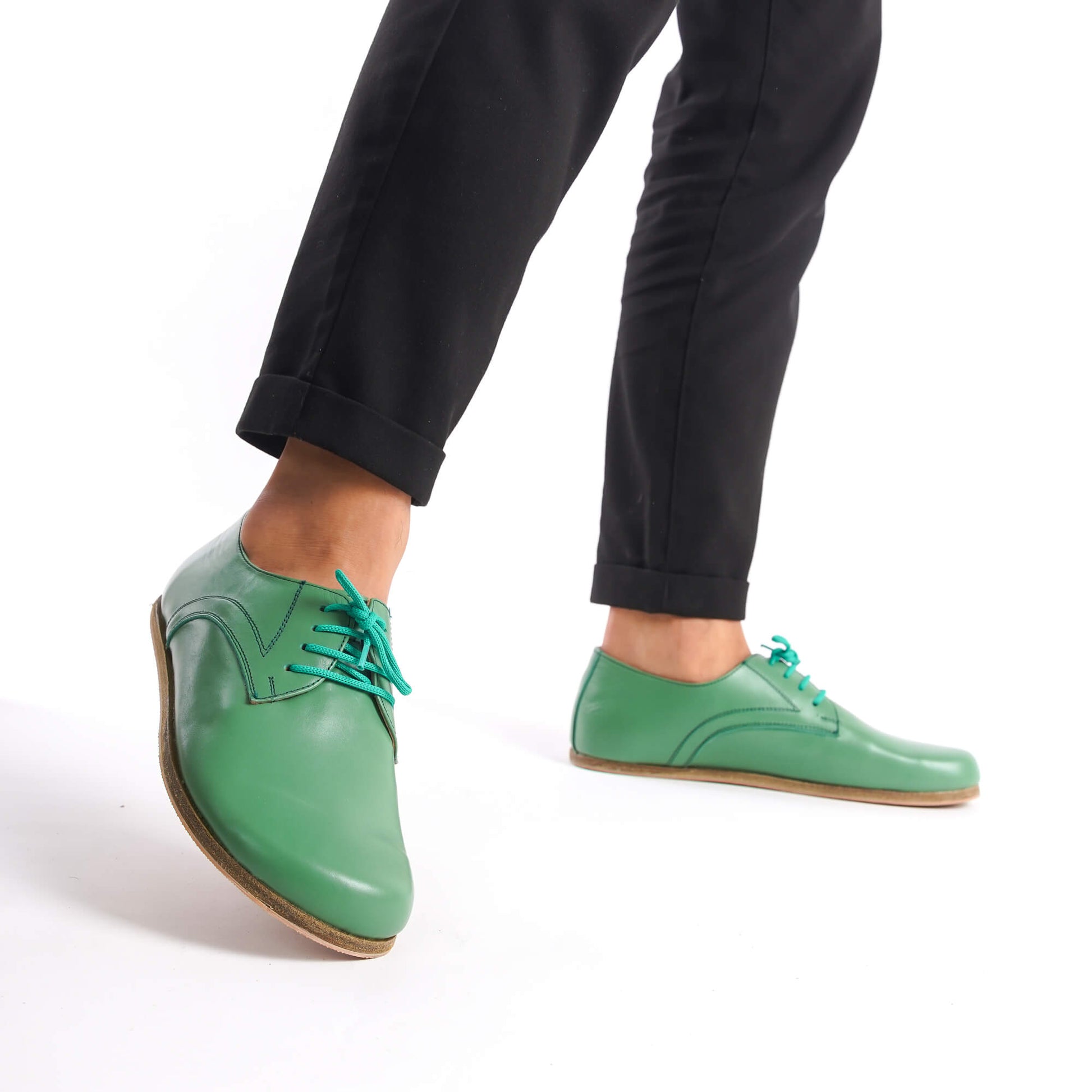 Walking shot of Locris Leather Barefoot Men's Oxfords in green, highlighting their natural fit and foot health benefits.