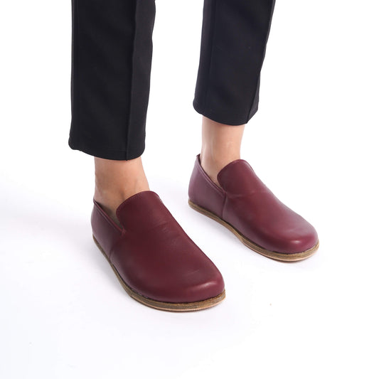 Close-up of Aeolia Leather Barefoot Women Loafers in Burgundy, paired with black pants.