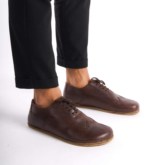 Close-up of brown Doris Leather Barefoot Men's Oxfords, showcasing high-quality leather and classic wingtip design.