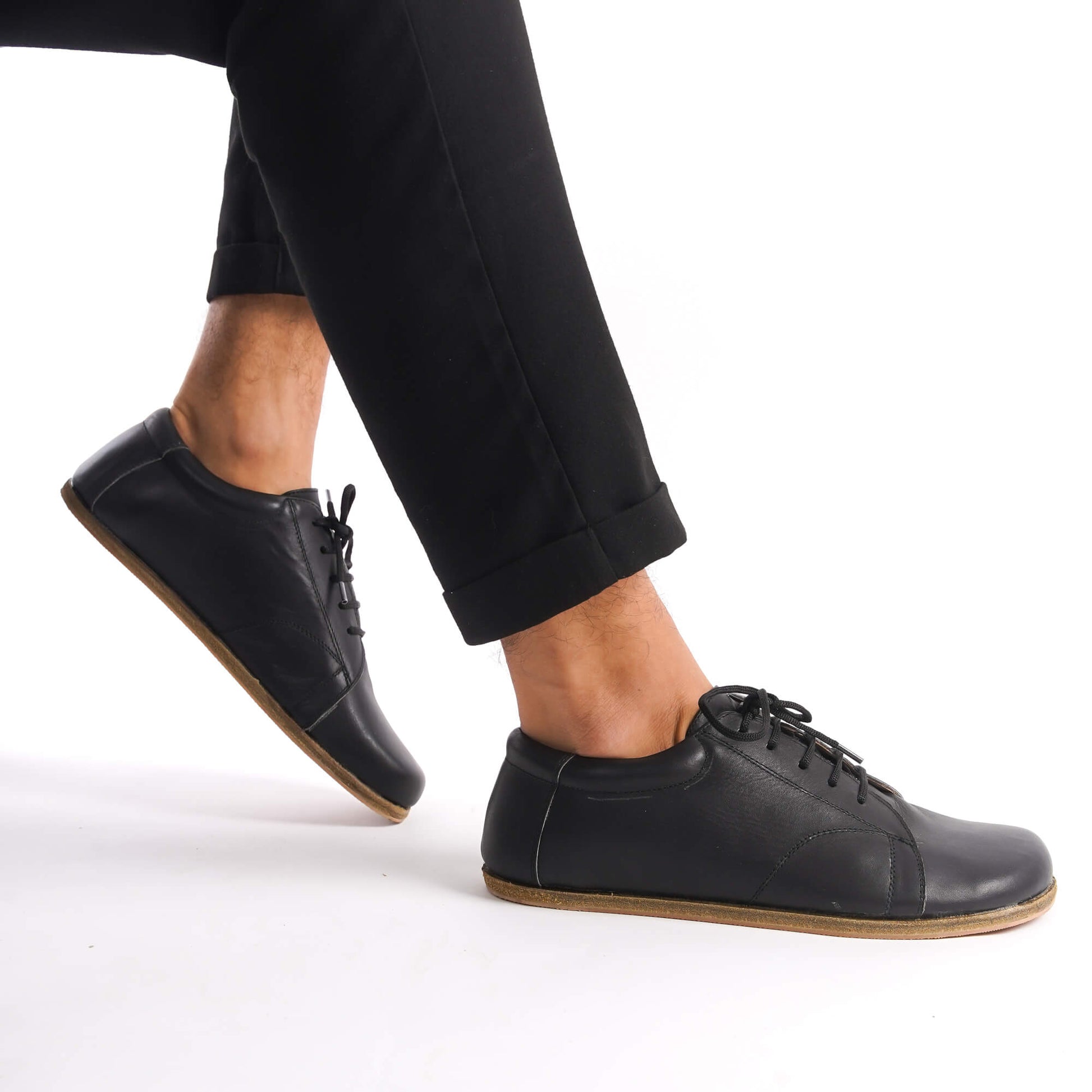 Side view of Black Lydia Leather Barefoot Men's Sneakers being worn, highlighting the minimalist design and natural foot alignment.