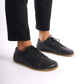 Person wearing Black Lydia Leather Barefoot Men's Sneakers, emphasizing the barefoot feel and flexible sole.