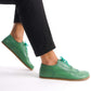 Close-up of green Doris Leather Barefoot Oxfords showcasing brogue details and natural foot shape.