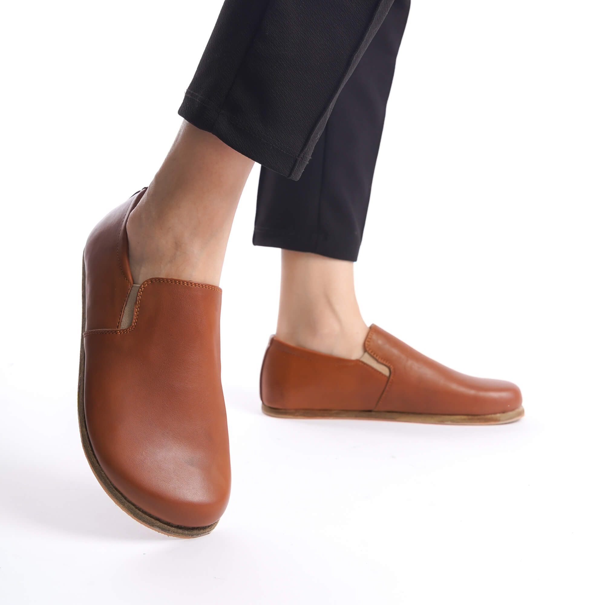 Close-up view of tan brown Ionia leather barefoot loafers, highlighting their premium leather quality and sleek design.