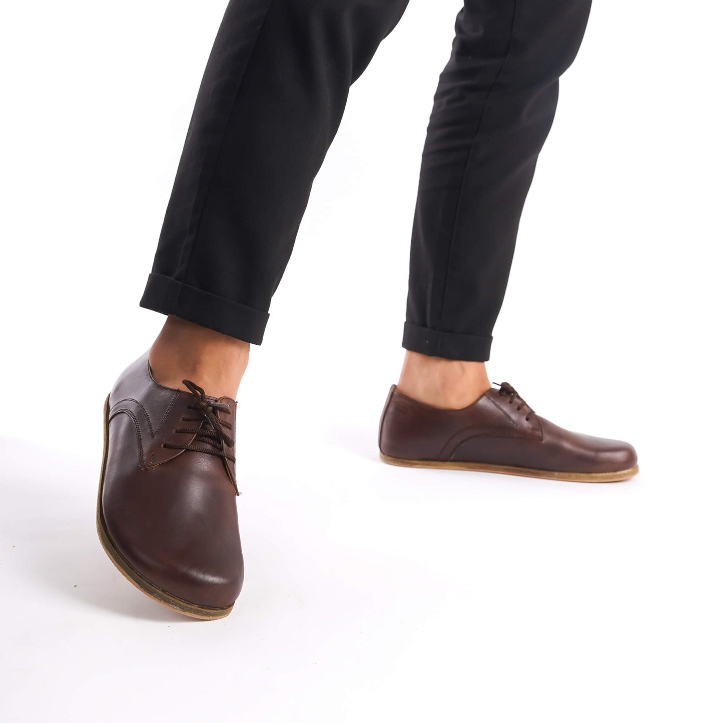 Walking shot of Locris Leather Barefoot Men's Oxfords in brown, showing their flexibility and lightweight construction.