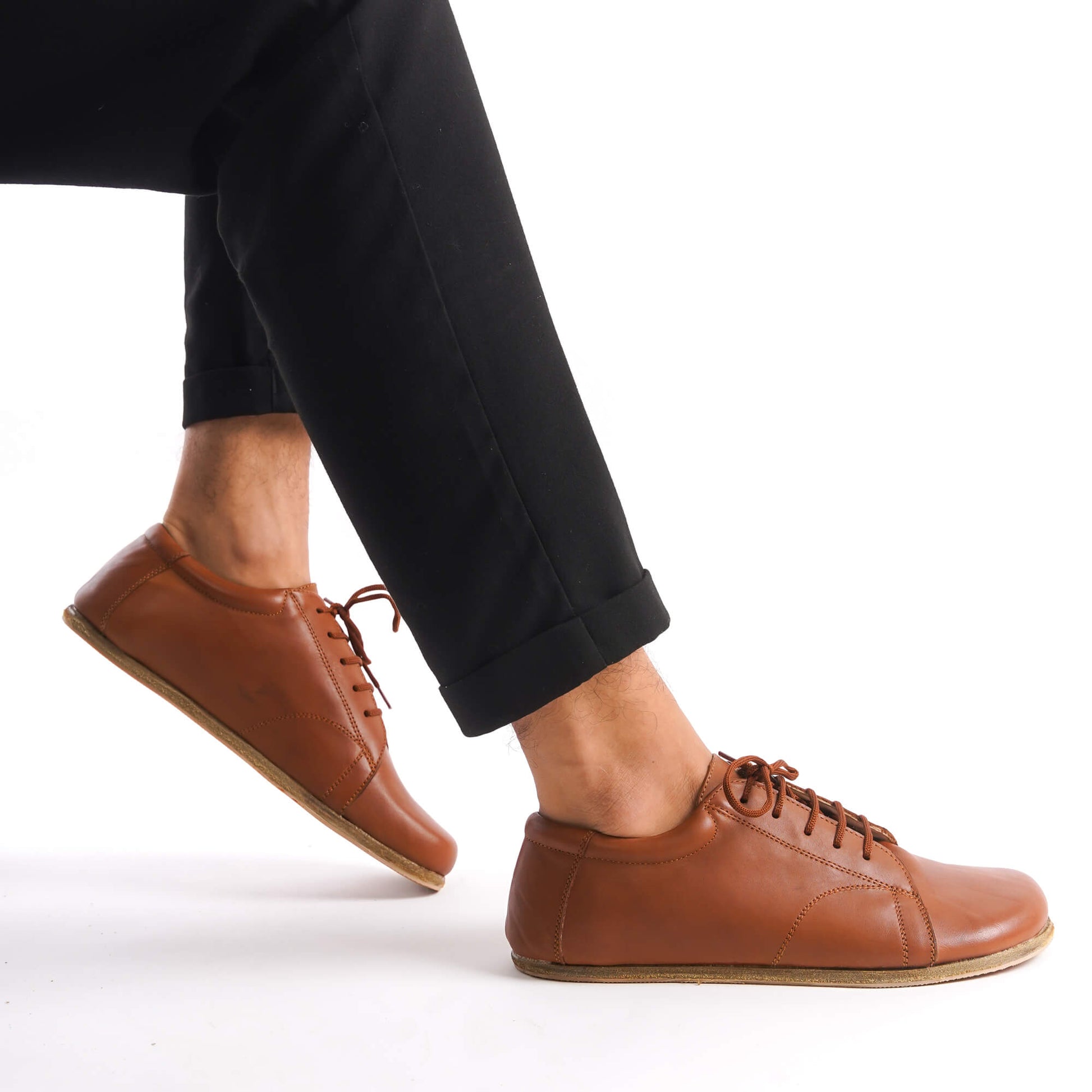 Tan brown Lydia Leather Barefoot Men's Sneakers on feet, highlighting flexibility and natural movement.