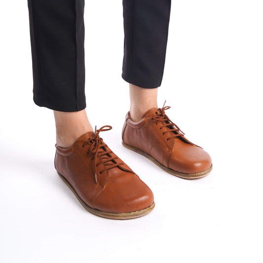 Lydia Leather Barefoot Women's Sneakers in Tan Brown, emphasizing the sleek design and natural fit for foot health.