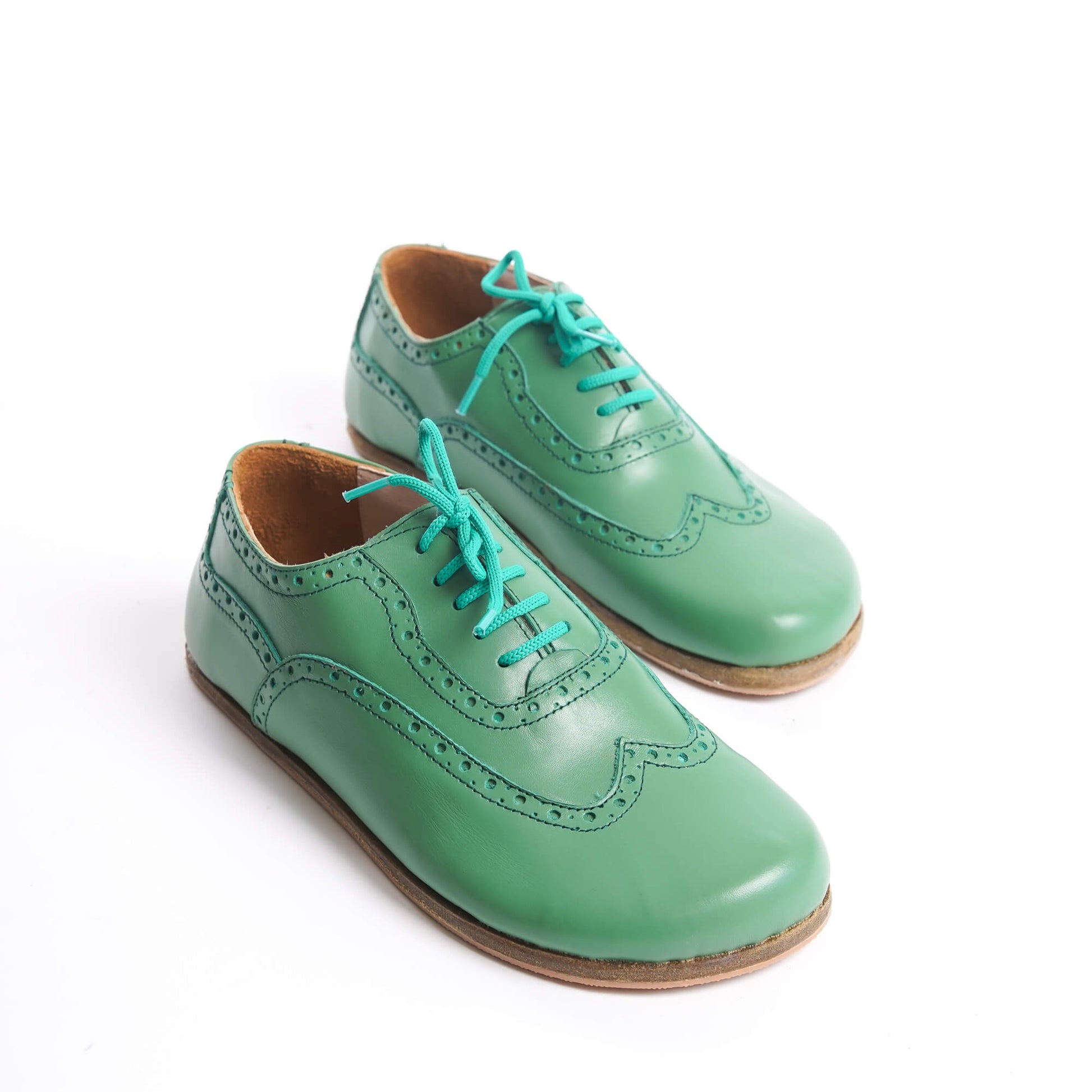 Close-up view of the green Doris Leather Barefoot Women Oxfords with intricate brogue detailing, showcasing their vibrant color and design.