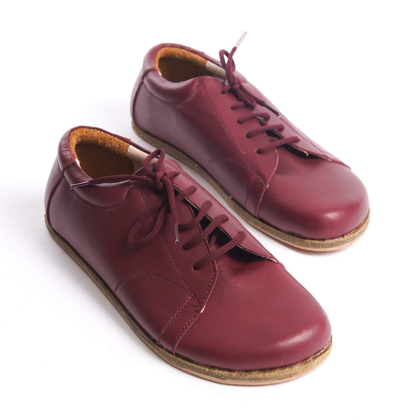 Burgundy leather barefoot women's sneakers, featuring a wide toe box and zero-drop design for natural foot movement and comfort.