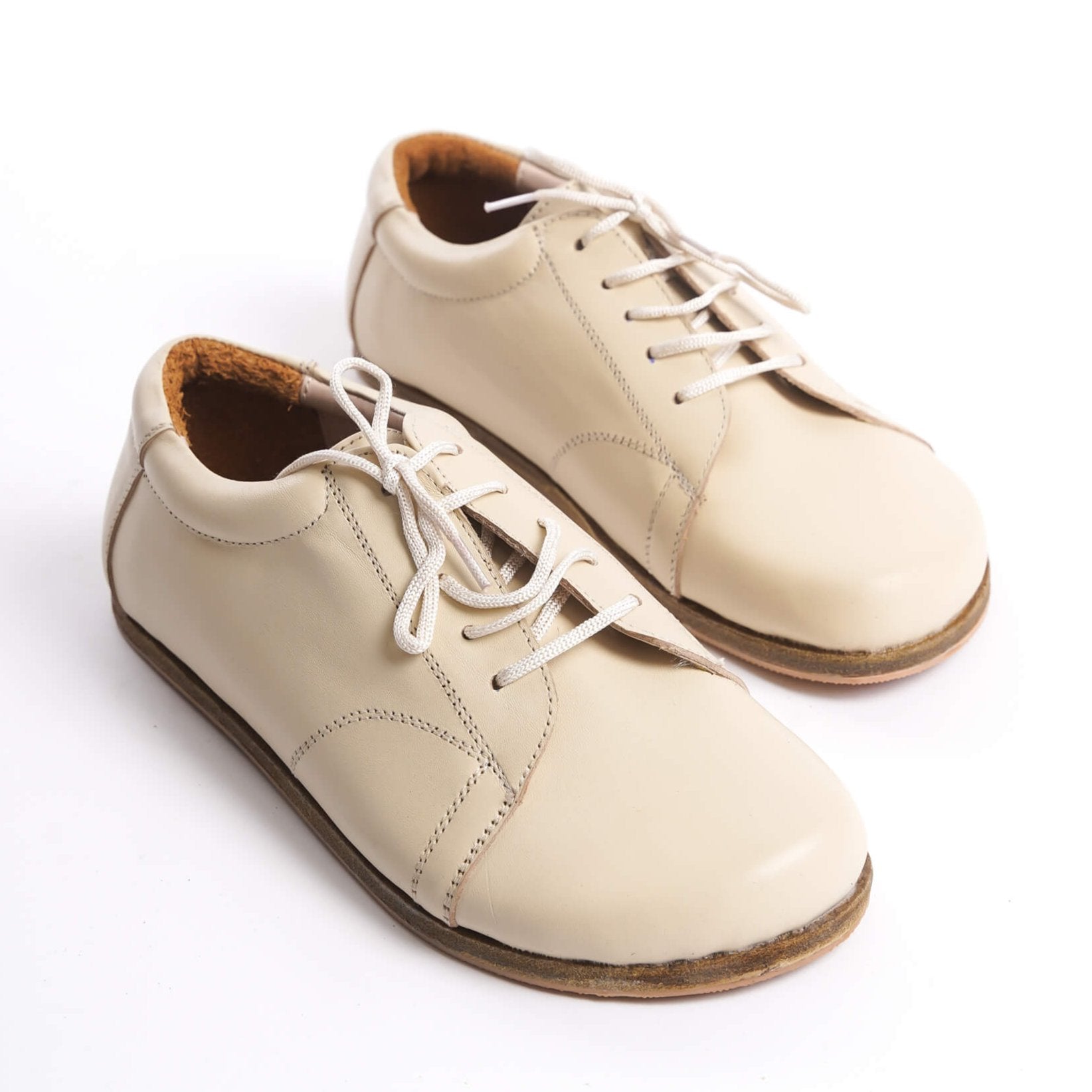 Beige leather barefoot women's sneakers showcasing detailed laces and natural materials for ultimate comfort and style.