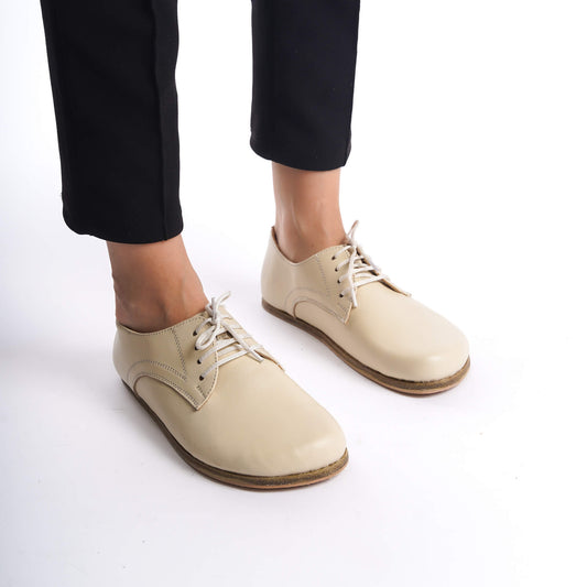Front view of Locris beige leather barefoot women's oxfords worn with black pants, emphasizing comfort and style.