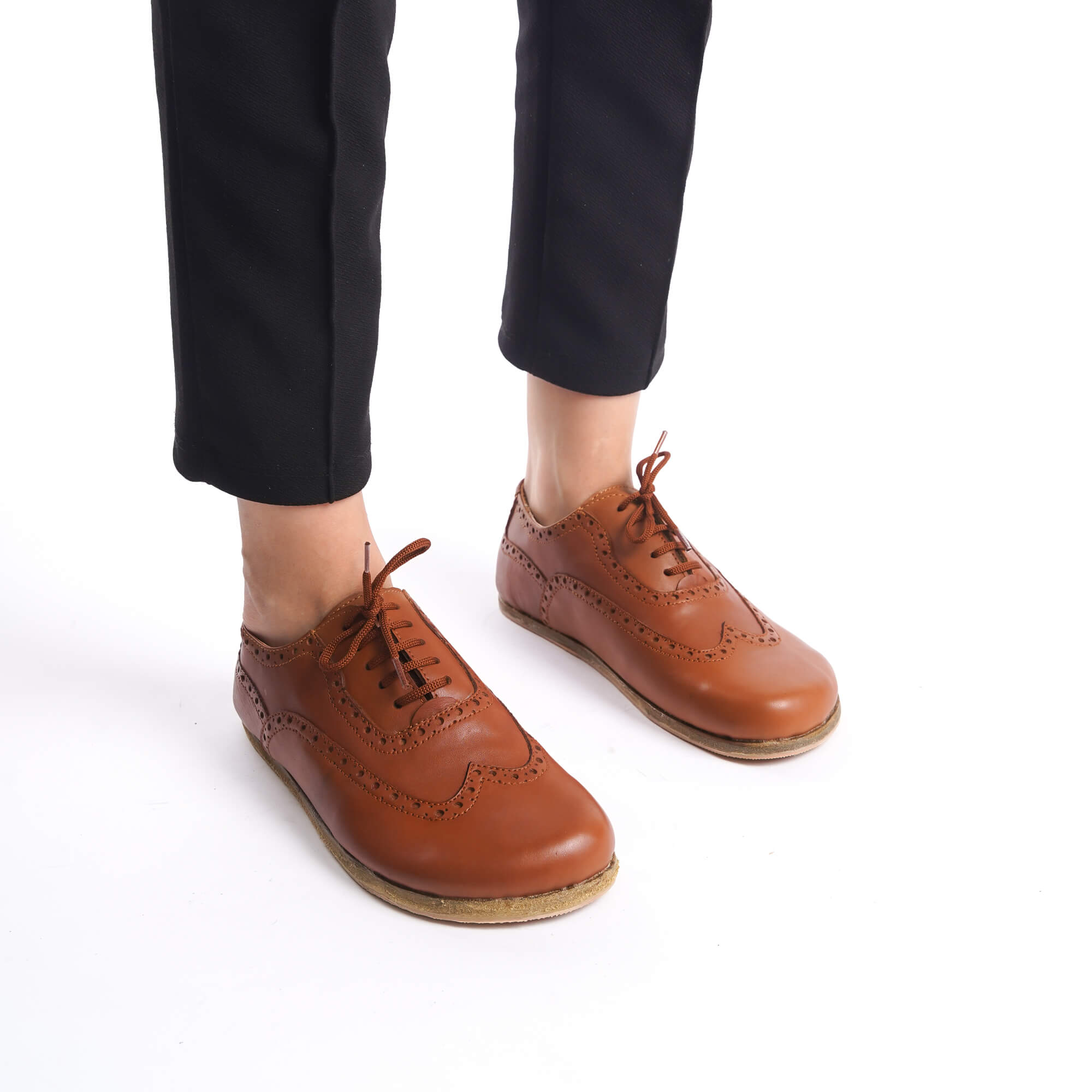Model standing with feet together, showcasing the tan brown Doris leather barefoot women Oxfords in a stylish outfit.