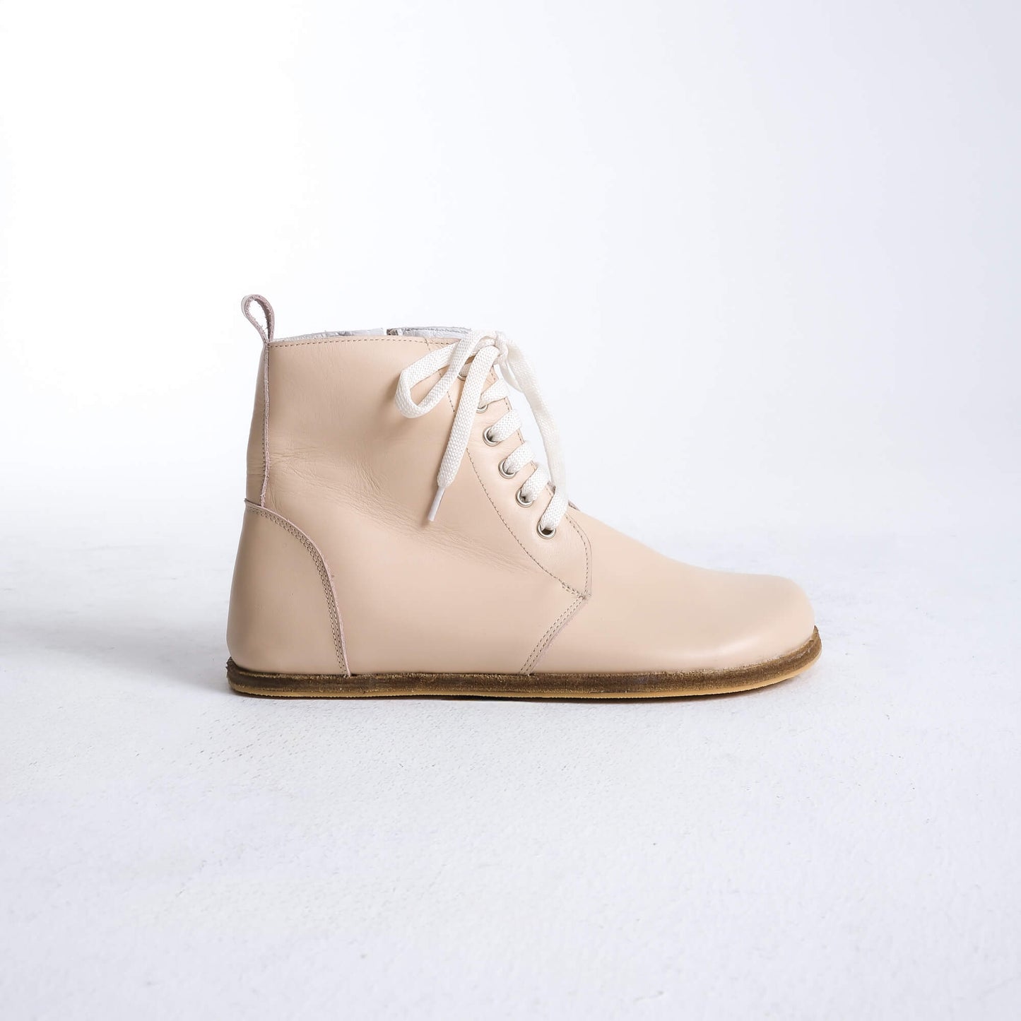 Versatile beige barefoot boots featuring a unique design and sturdy construction for all-day wear.