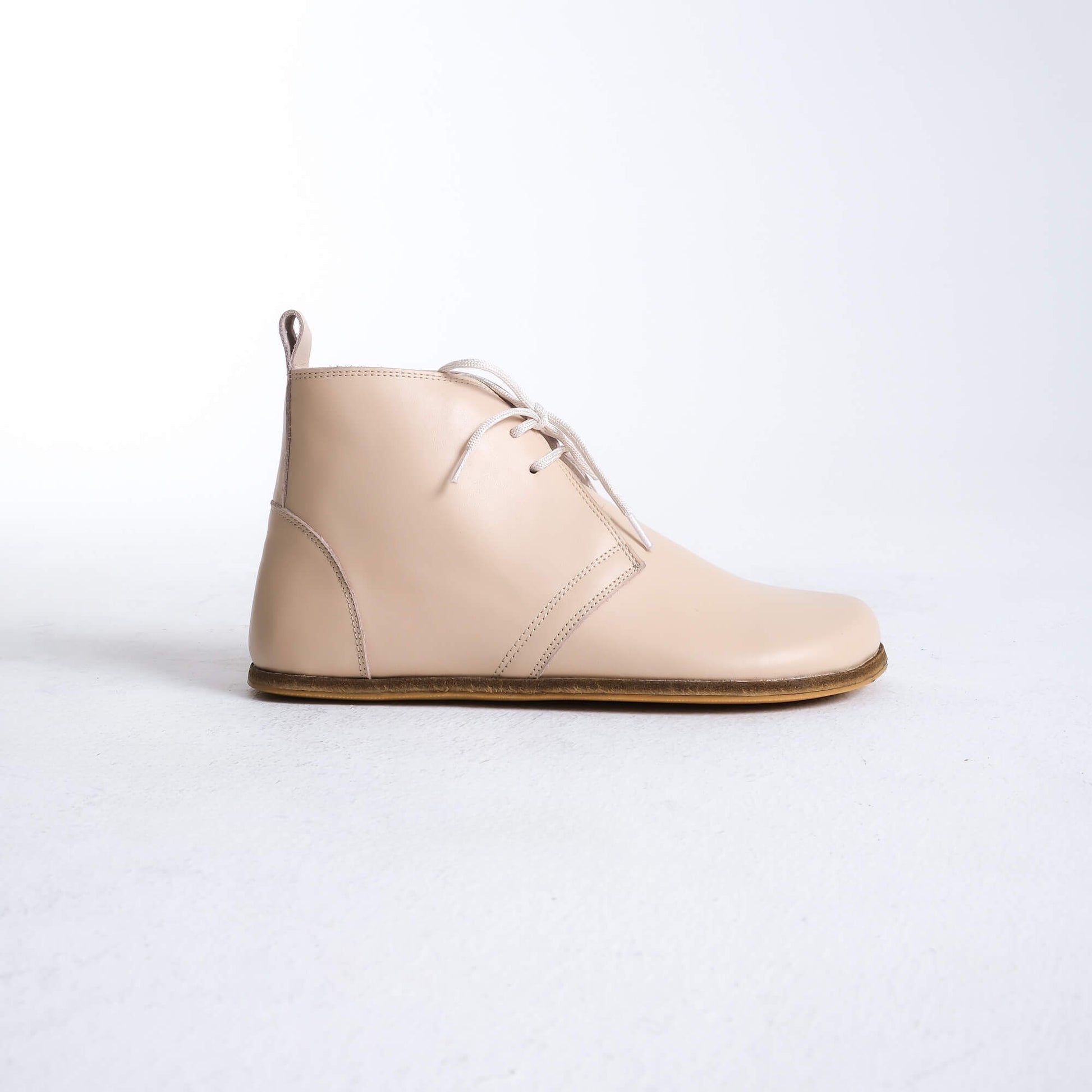 Trendy beige barefoot boots featuring a unique design for ultimate comfort.