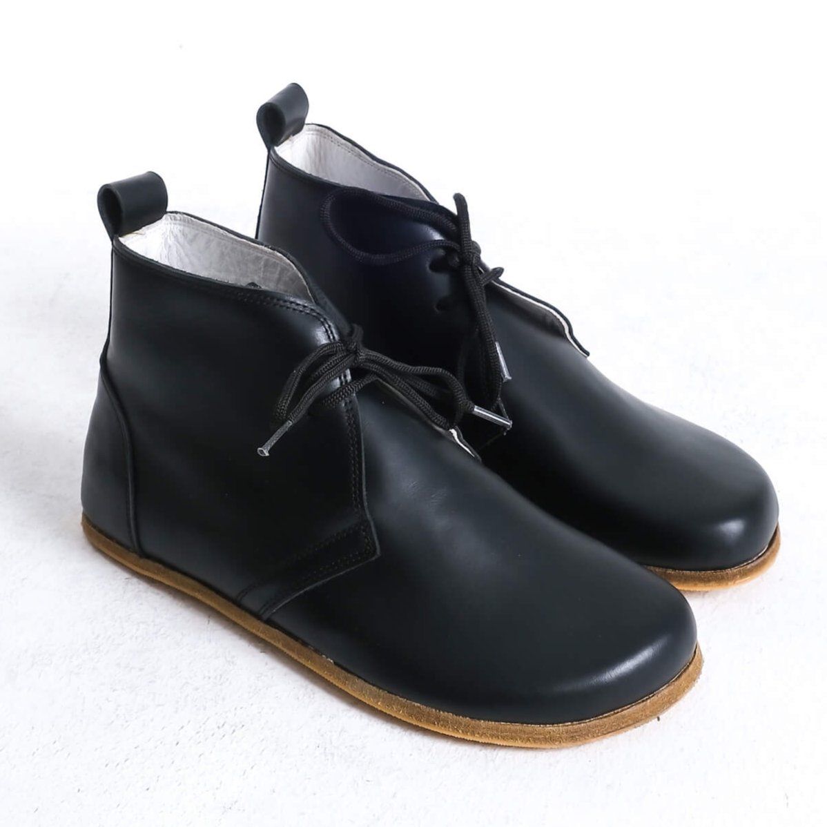 Stylish black barefoot ankle boots with a minimalist design, perfect for comfort.