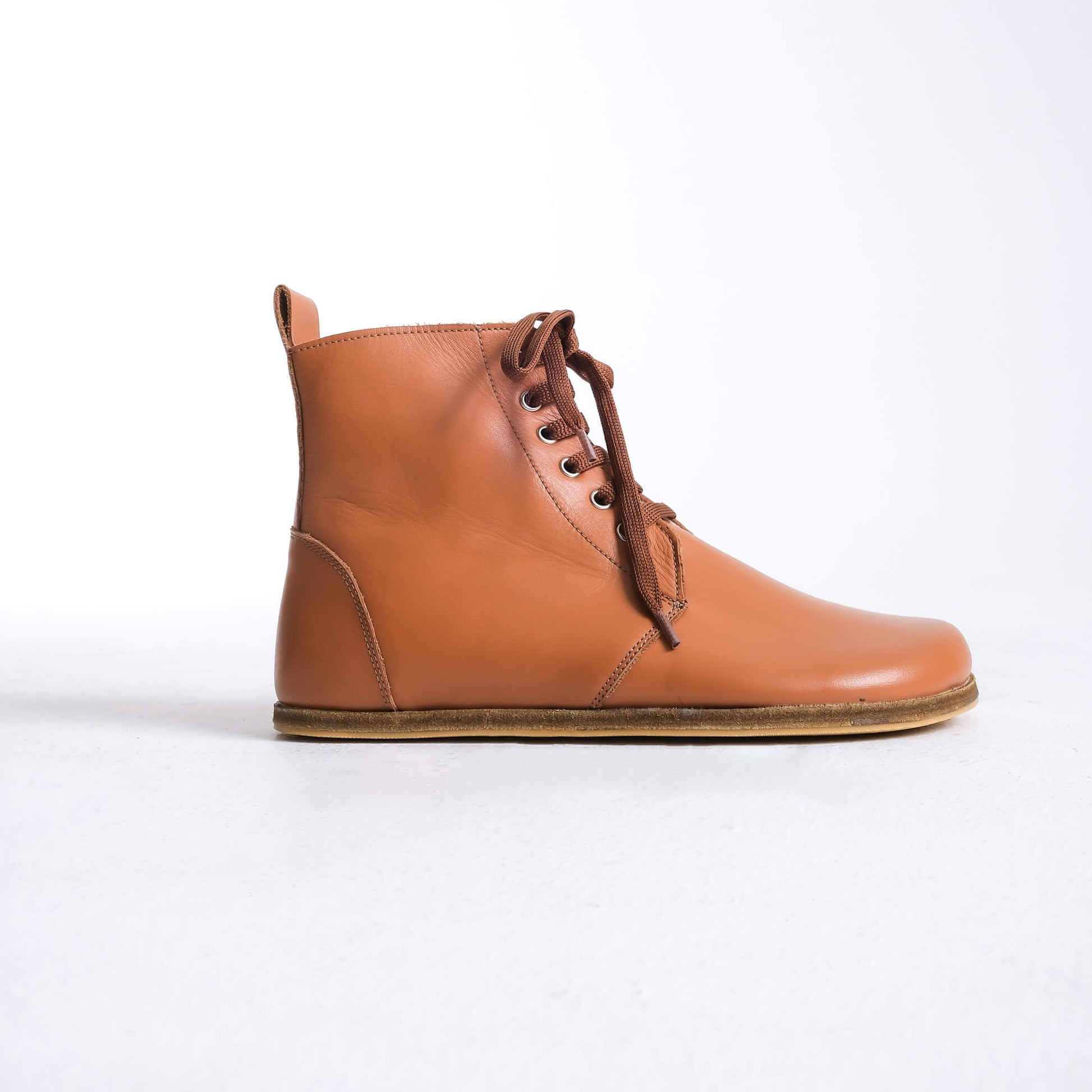 Versatile tan brown barefoot boots featuring a unique design and sturdy construction for all-day wear.