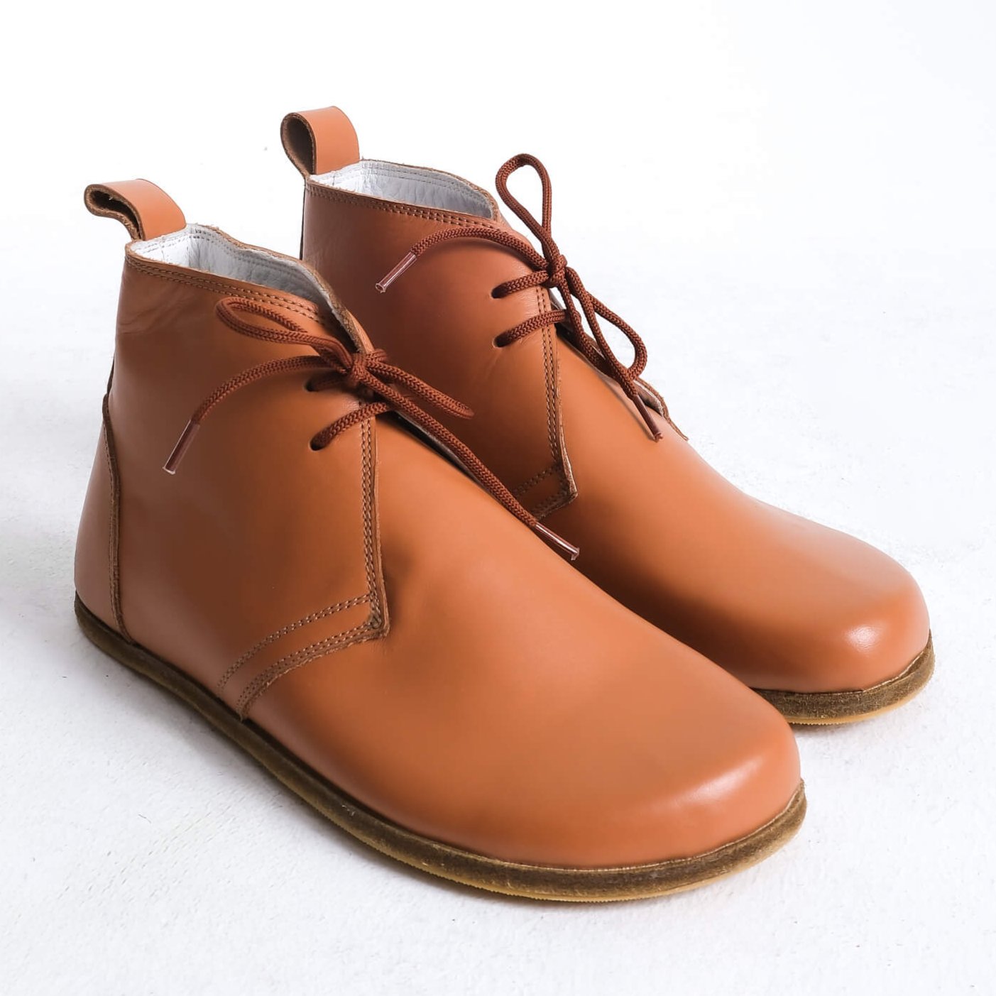 Stylish tan brown barefoot ankle boots with a minimalist design, perfect for comfort.