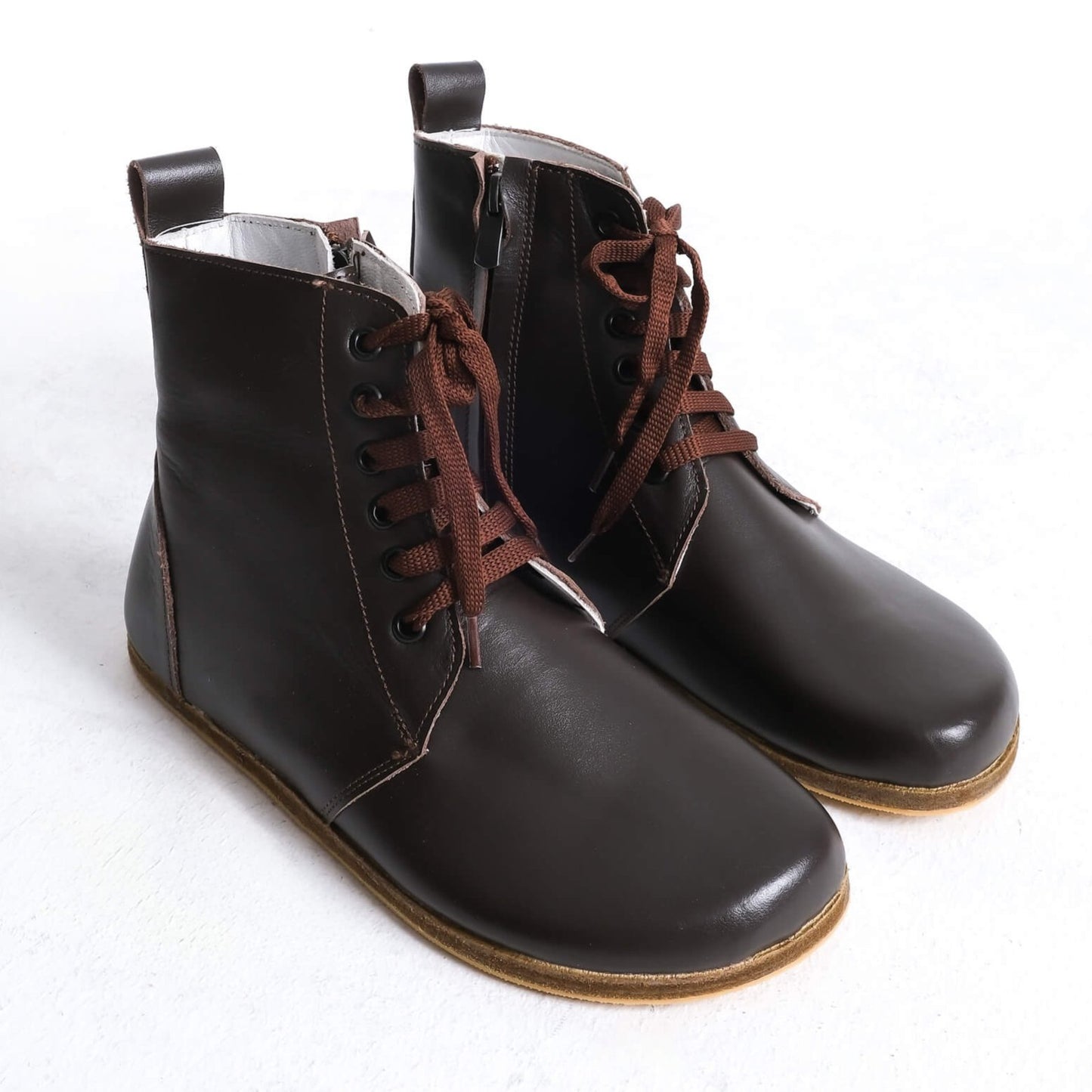 Stylish brown barefoot ankle boots with a sleek design and lace-up front, perfect for modern casual wear.