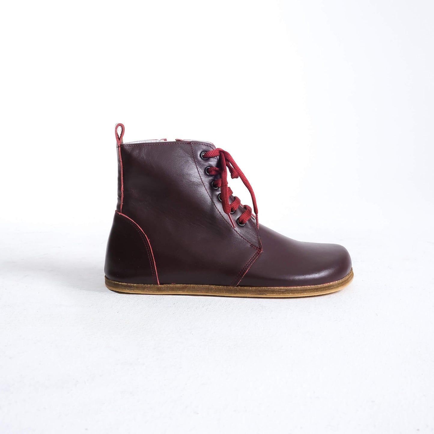 Versatile burgundy barefoot boots featuring a unique design and sturdy construction for all-day wear.