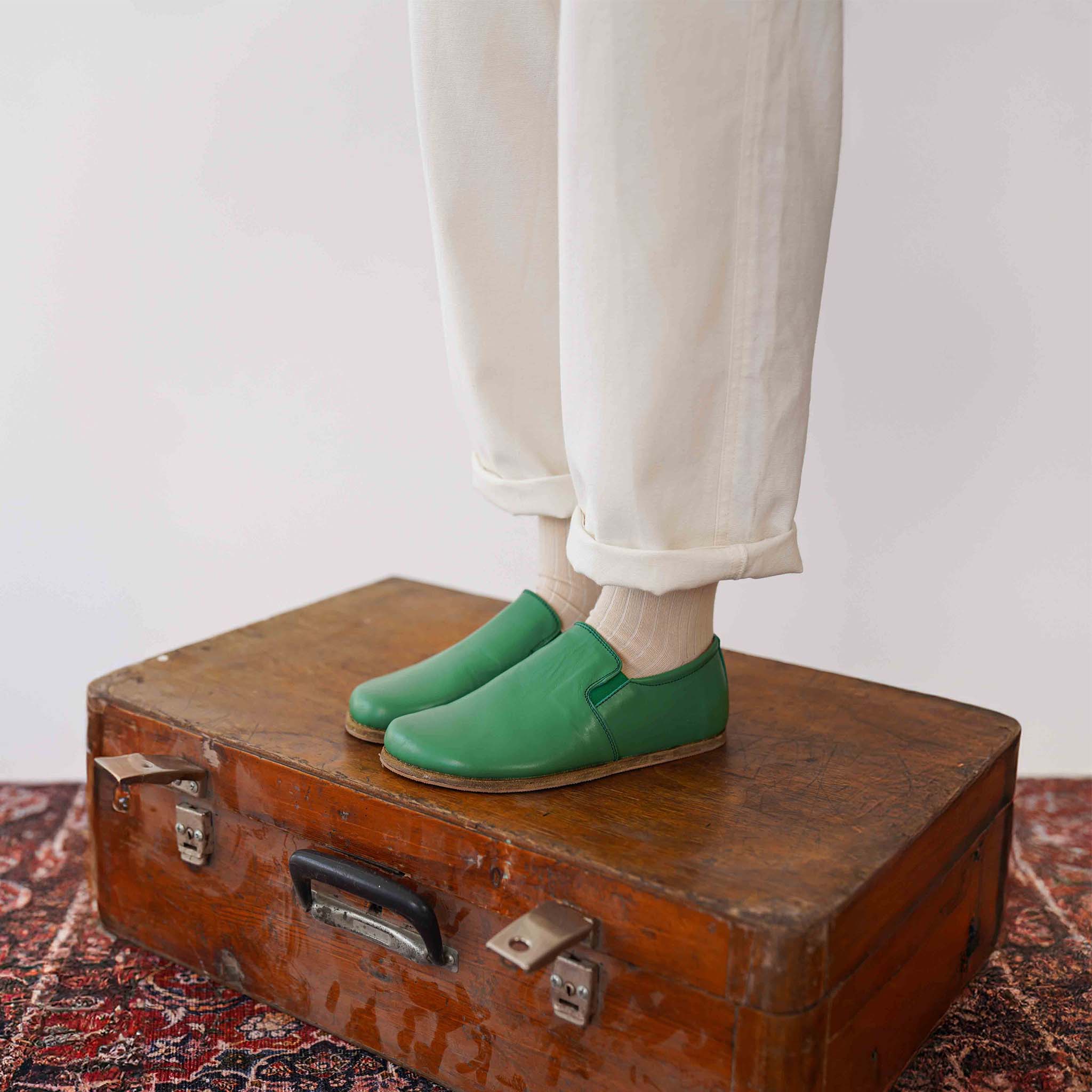 Side view of green leather loafers on feet. Shop Pelanir's genuine leather barefoot shoes for women.