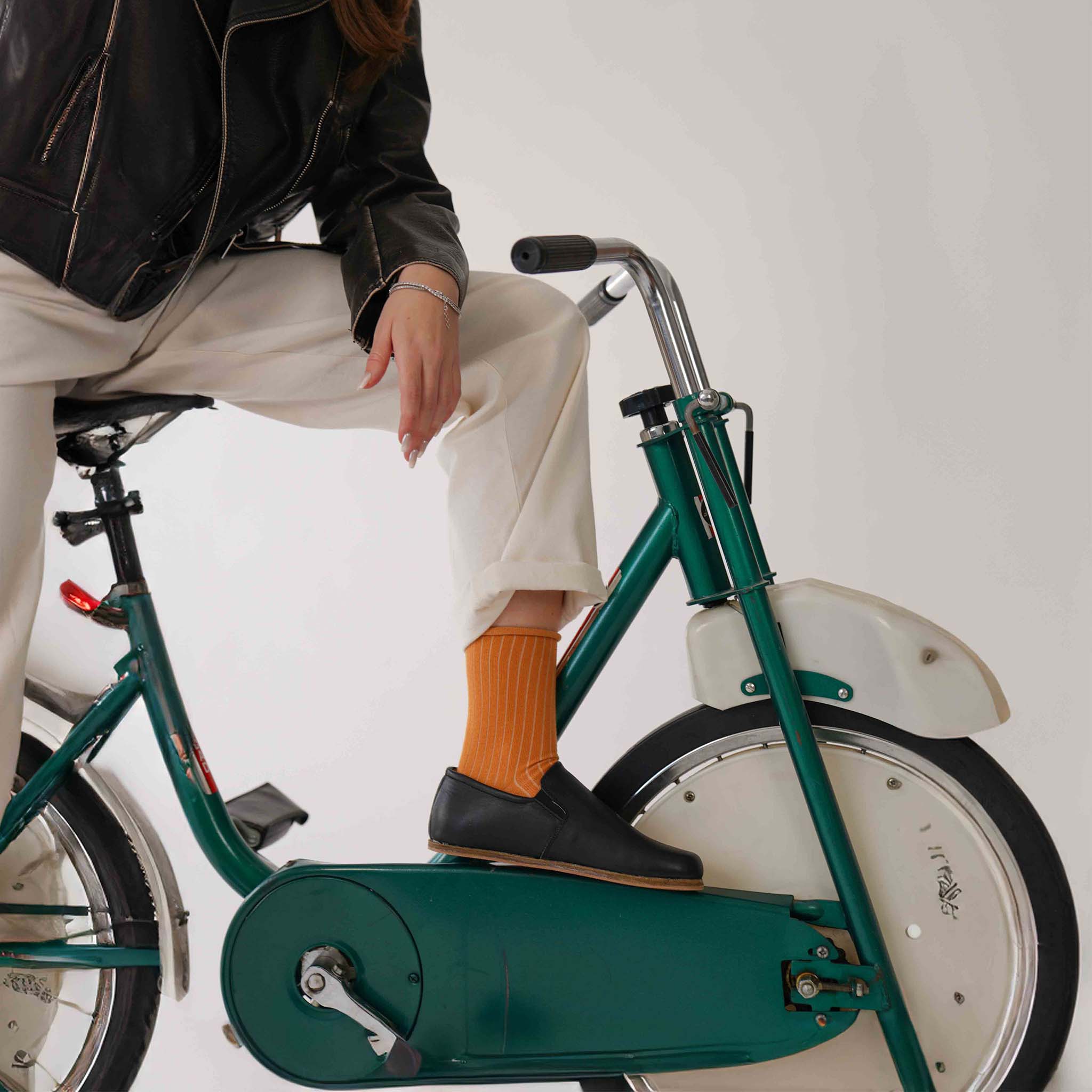 Woman Posing with Black Ionia Loafers on Exercise Bike