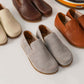 Aeolia gray suede barefoot women loafers displayed among other leather loafers in various colors.