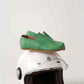 Close-up of green leather Aeolia loafer for women. Resting on white motorcycle helmet.