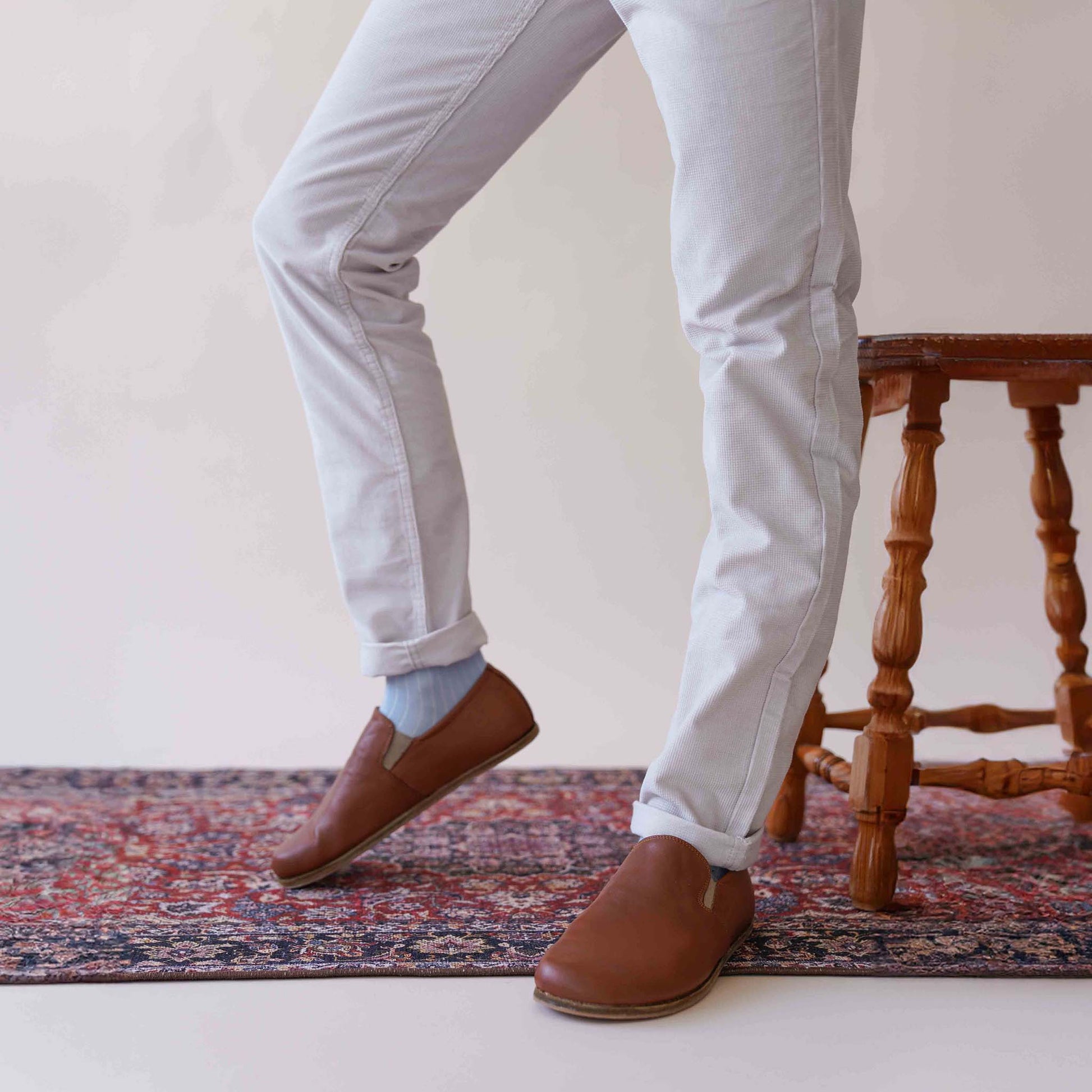 Close-up of tan brown Ionia leather barefoot loafers, paired with light-colored pants, showcasing the versatile and stylish design. Explore at pelanir.com!