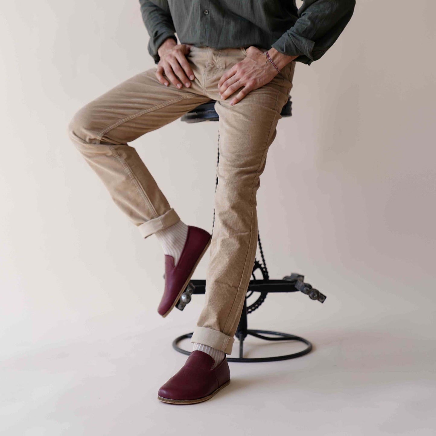 Comfortable Burgundy Aeolia Leather Barefoot Men's Loafers paired with beige pants and white socks, highlighting the casual style.