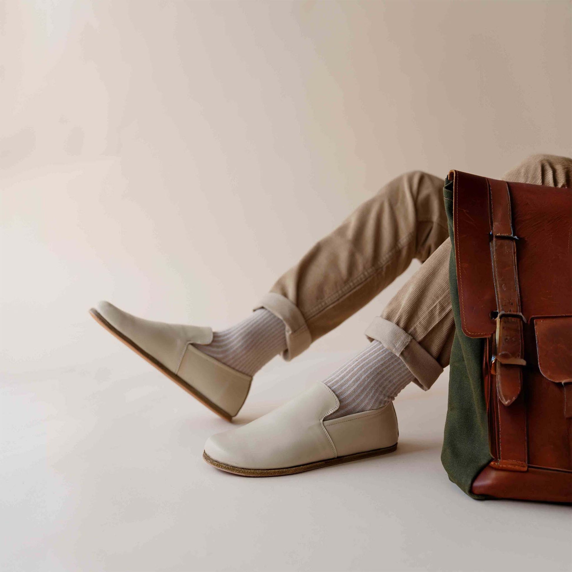 Relaxed look featuring beige Aeolia Leather Barefoot Men's Loafers and a brown leather backpack. Shop at pelanir.com!
