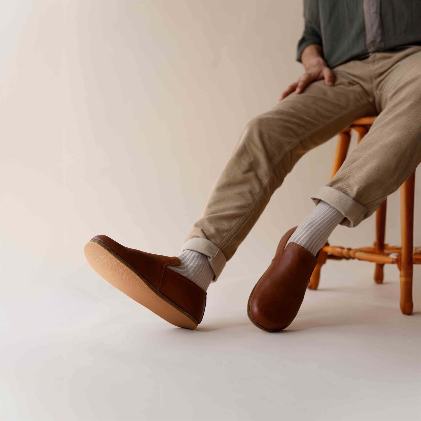 Relaxed style with Tan brown Aeolia Leather Barefoot Men's Loafers, paired with beige pants and white socks, ideal for everyday comfort.