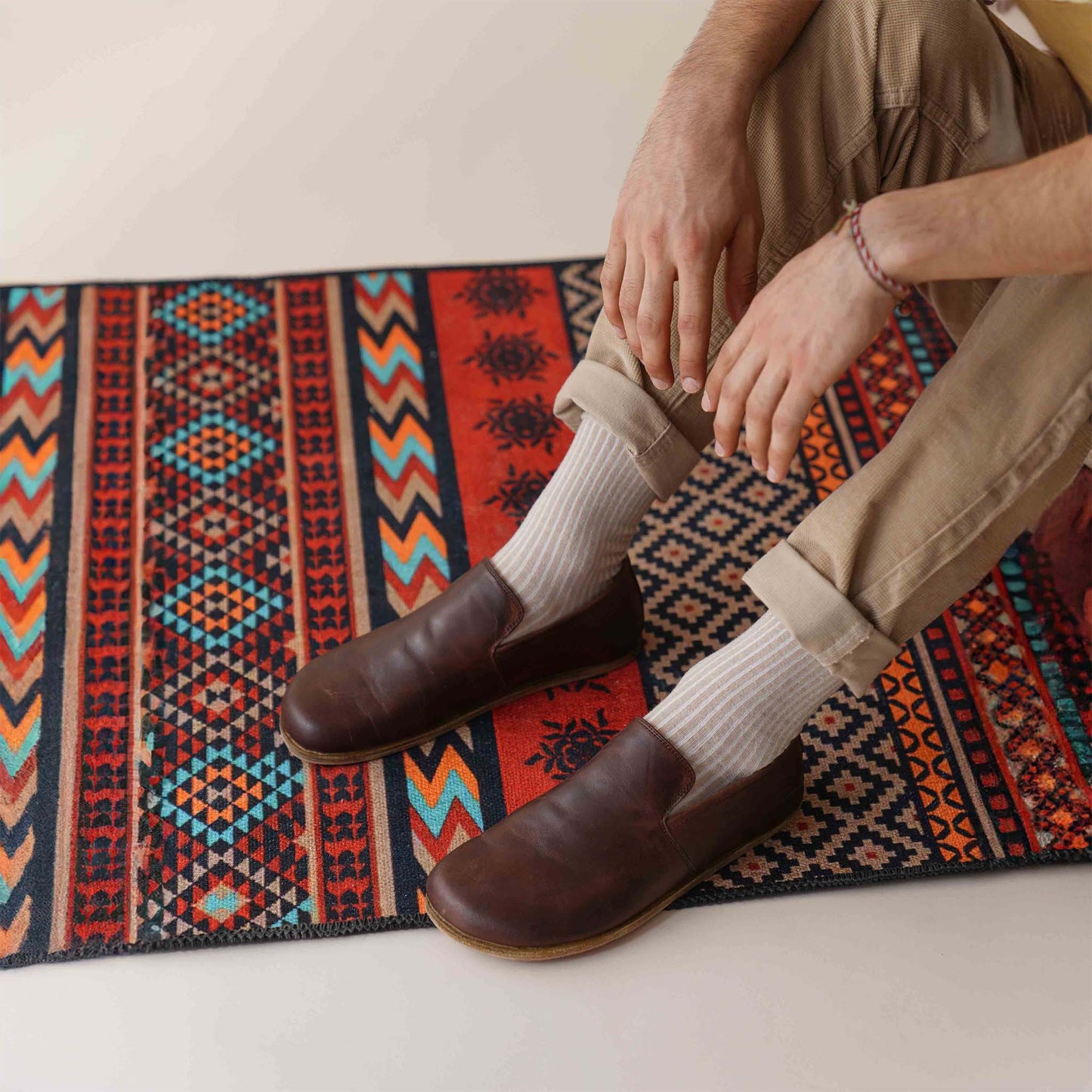 Comfortable brown Aeolia Leather Barefoot Men's Loafers on a vibrant patterned rug. Get yours at pelanir.com!