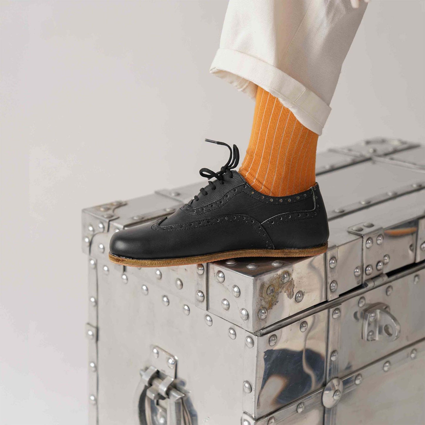 Side view of black Doris Leather Barefoot Women Oxfords being worn, highlighting comfort and style with orange socks.