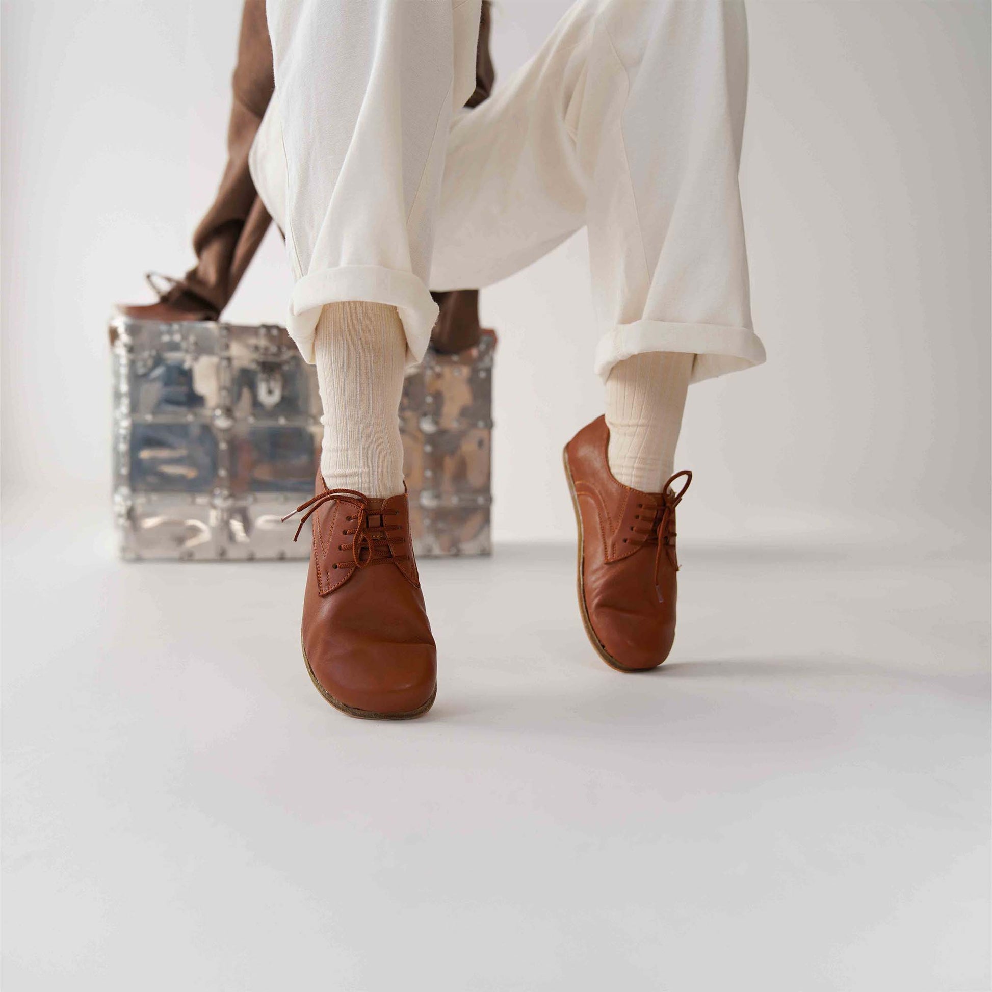 Tan brown leather barefoot women Oxfords styled with white pants, showcasing a minimalist and elegant look for casual wear.