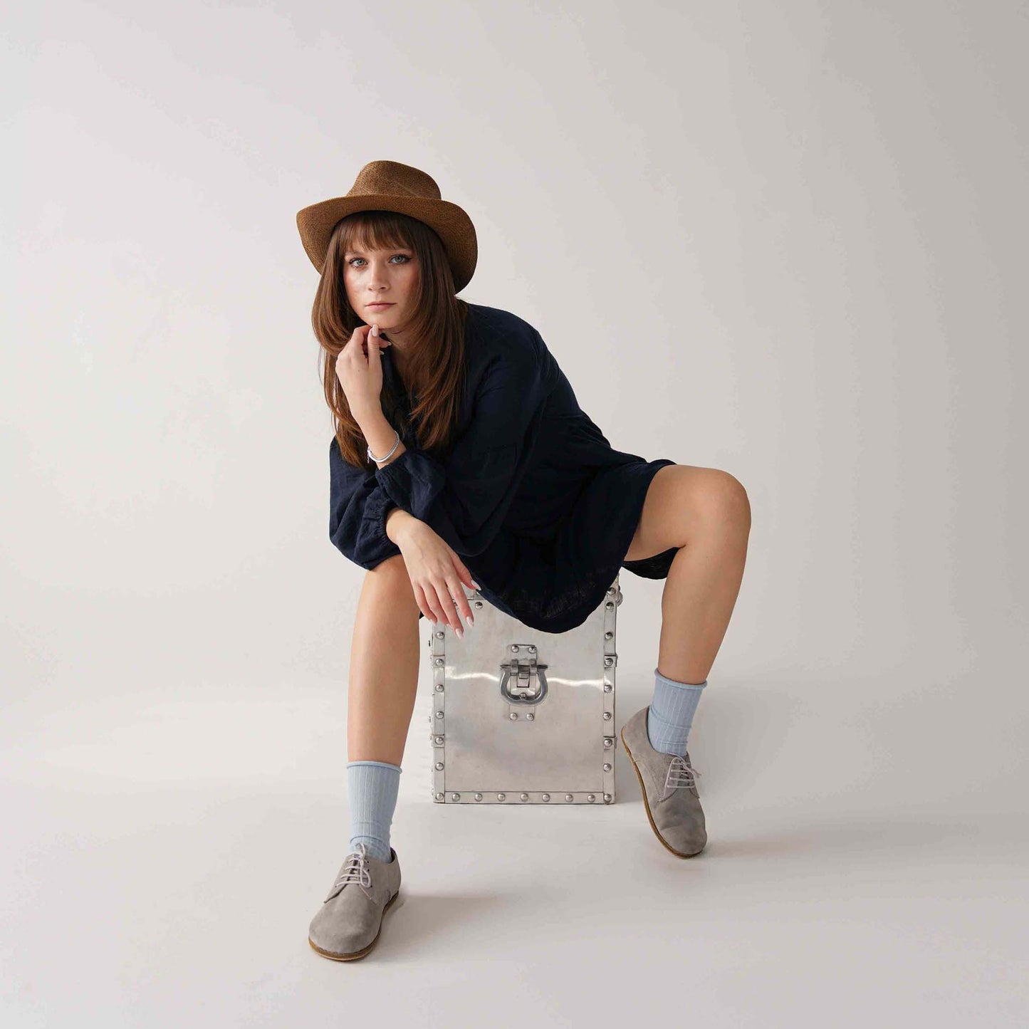 Model wearing gray suede Locris leather barefoot women oxfords, paired with a navy dress and blue socks for a chic look.