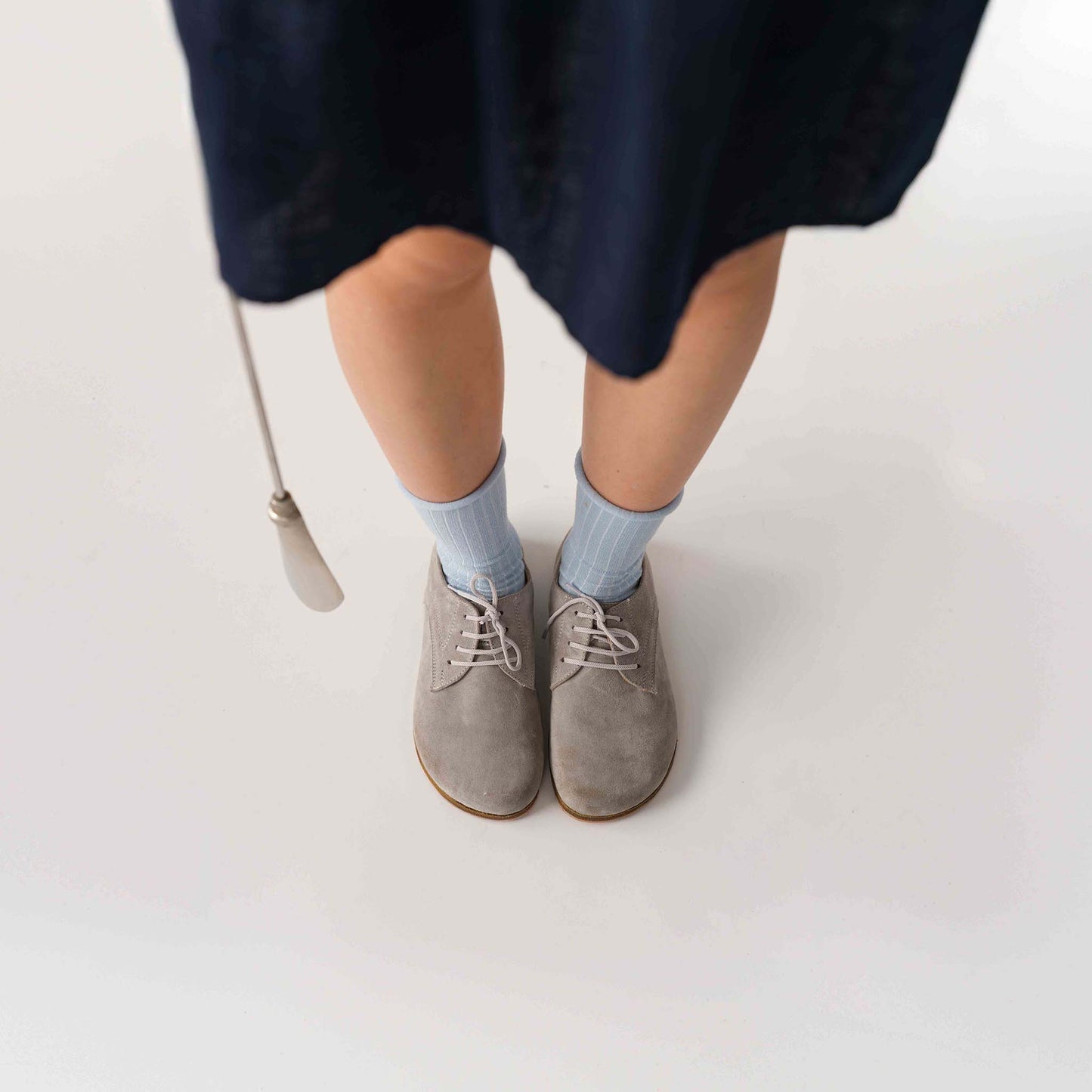 Woman wearing gray suede Locris Leather Barefoot Women Oxfords with blue socks, showcasing a stylish and comfortable look.