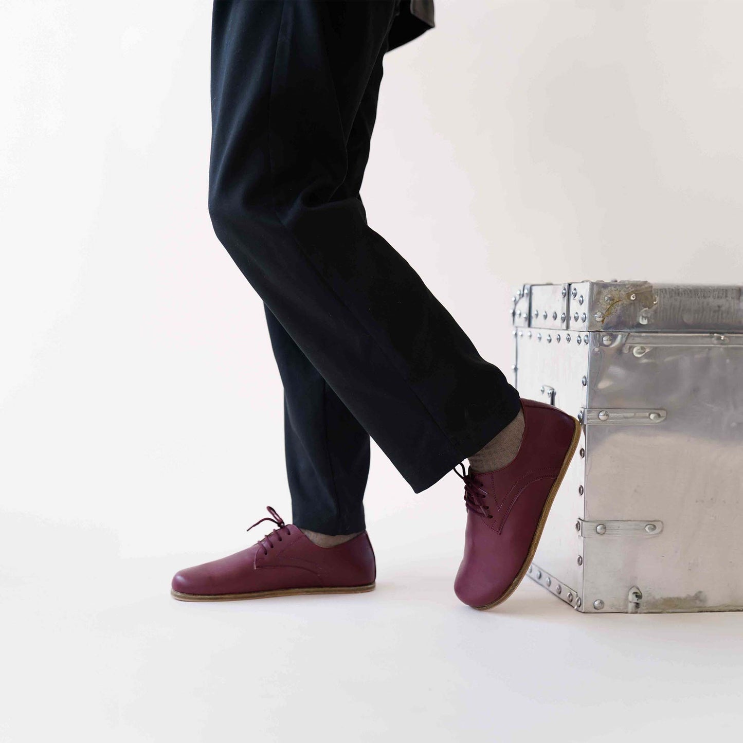 Walking shot of Locris Leather Barefoot Men's Oxfords in burgundy, showing their flexibility and natural fit.