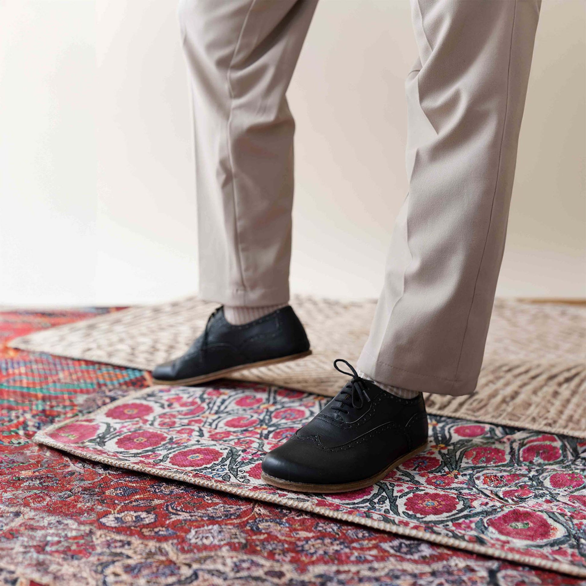 Black Doris Leather Barefoot Men's Oxfords styled with black pants, perfect for both casual and formal wear.