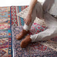 Man wearing tan brown Doris barefoot Oxfords paired with beige pants on a patterned rug – modern look.