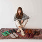 Burgundy leather barefoot sneakers neatly placed next to a vintage trunk, showcasing stylish and minimalist design.