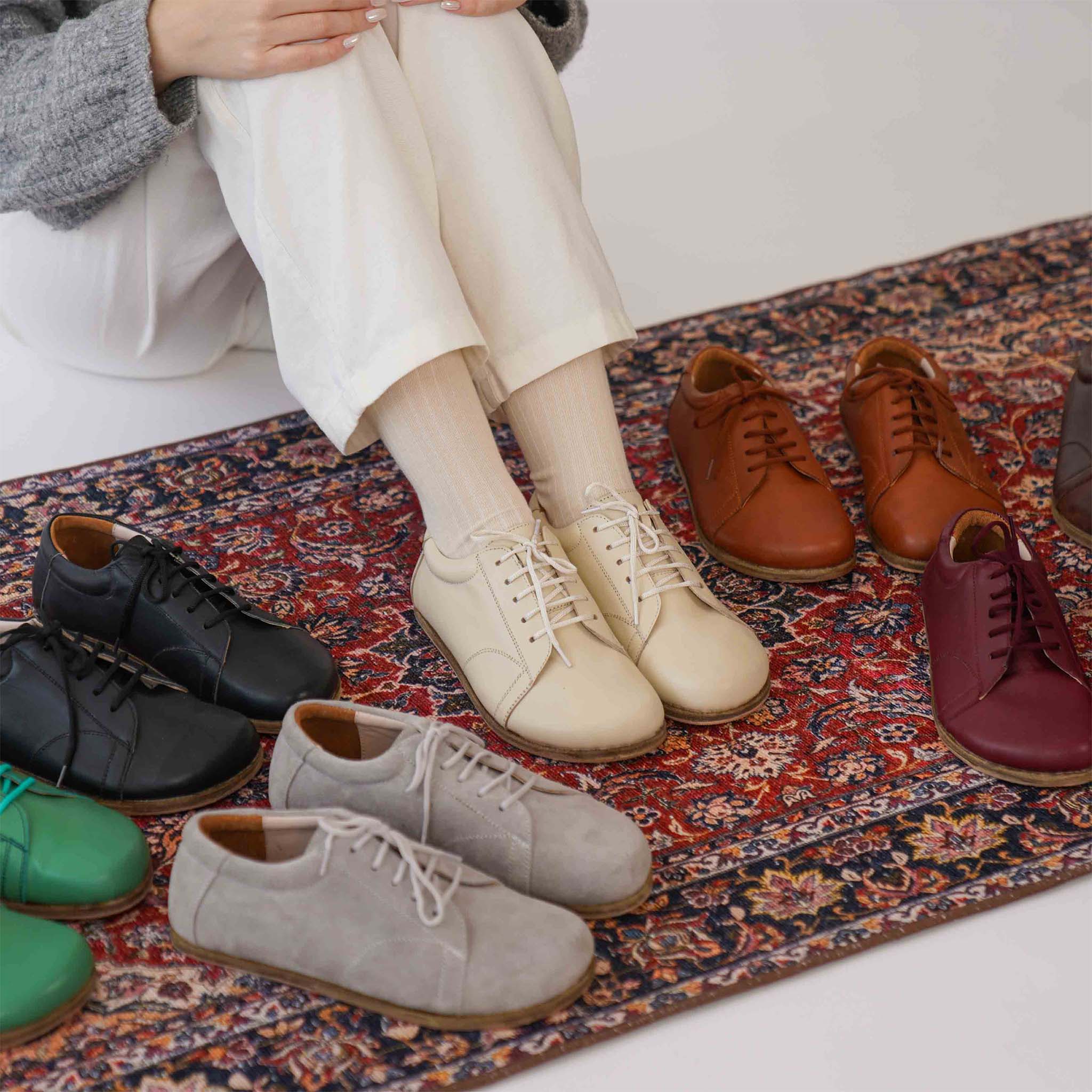 Beige leather barefoot women's sneakers surrounded by various colorful options, emphasizing versatility and elegance.